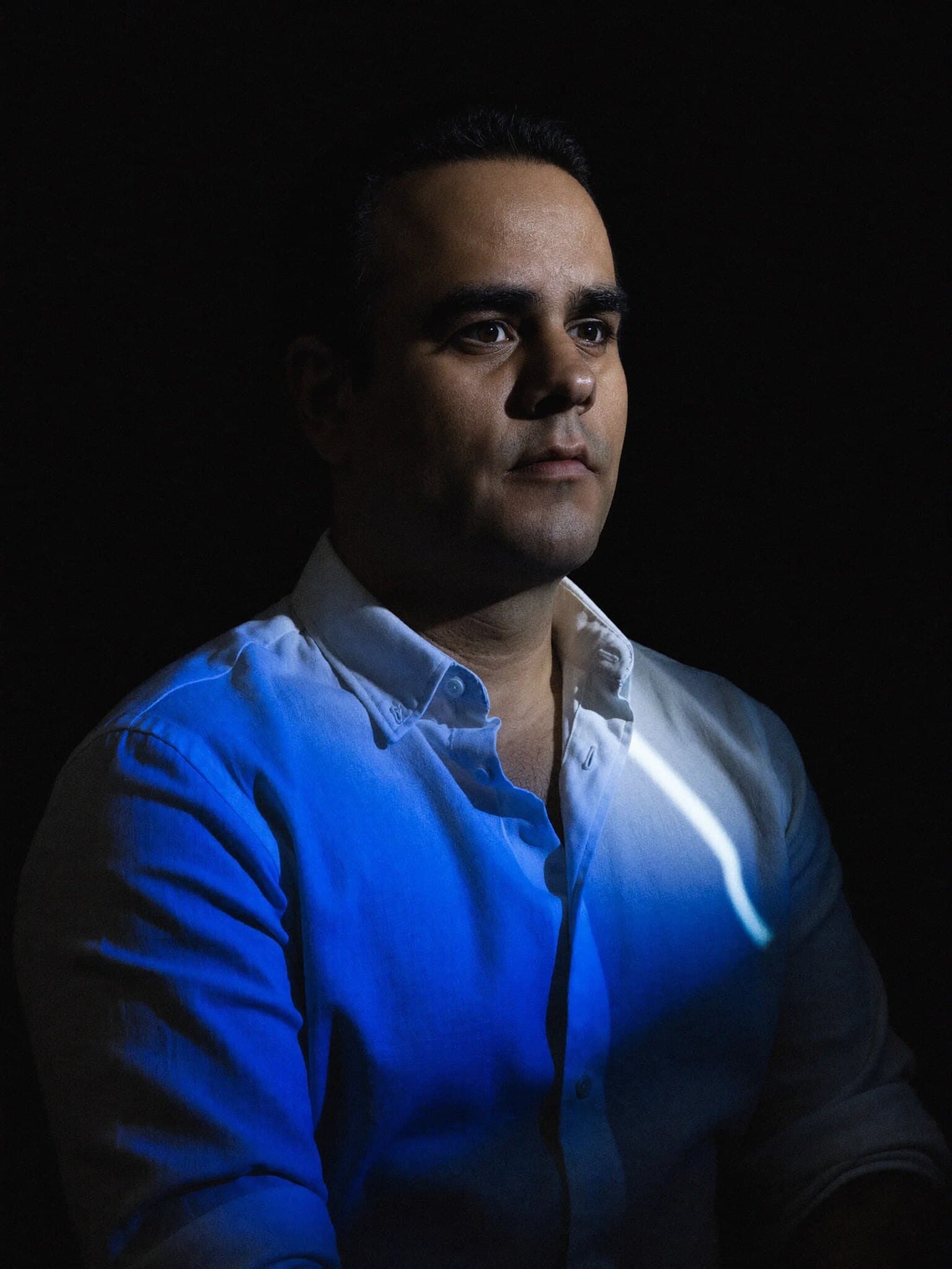 Edgard Vargas con camisa blanca e iluminación azul